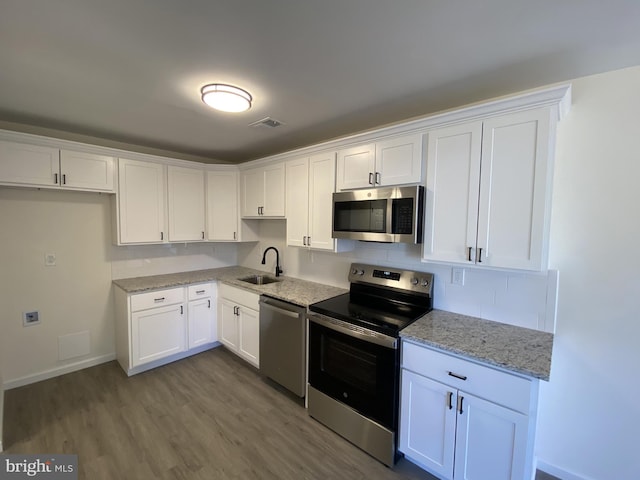 kitchen featuring a sink, stainless steel appliances, visible vents, and white cabinets