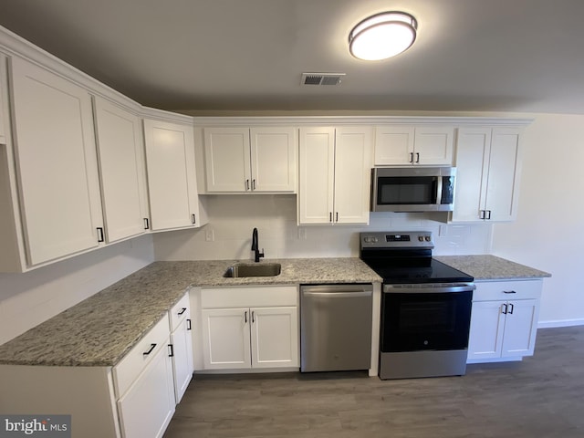 kitchen with white cabinets, appliances with stainless steel finishes, and a sink