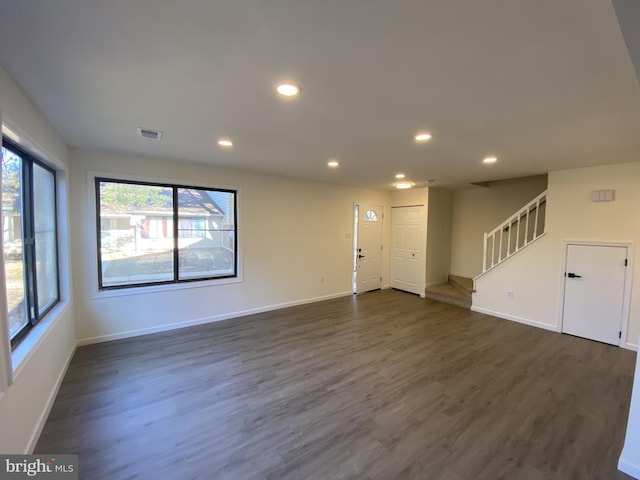 unfurnished living room with visible vents, stairs, recessed lighting, baseboards, and dark wood-style flooring