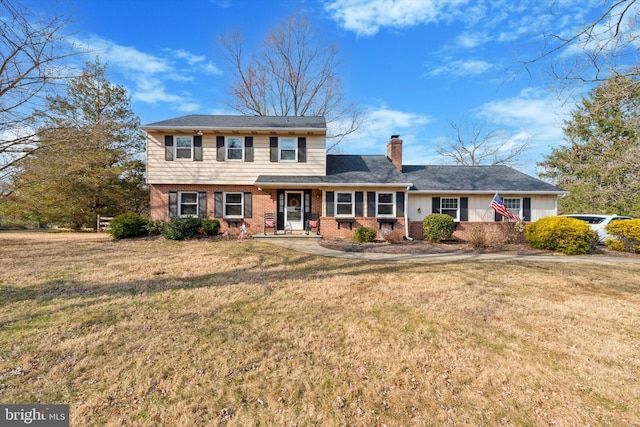 view of front of property with a front yard, brick siding, and a chimney