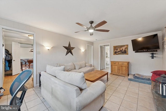 living area featuring crown molding, light tile patterned floors, and ceiling fan