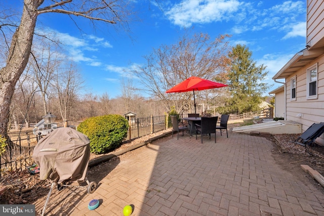 view of patio with a fenced backyard, a grill, and outdoor dining space