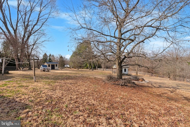 view of yard featuring an outdoor structure and fence