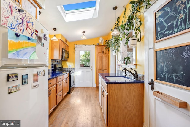 kitchen featuring range with electric stovetop, freestanding refrigerator, black microwave, and dark countertops