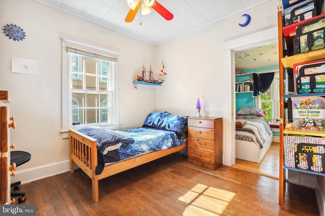 bedroom featuring crown molding, baseboards, and hardwood / wood-style flooring