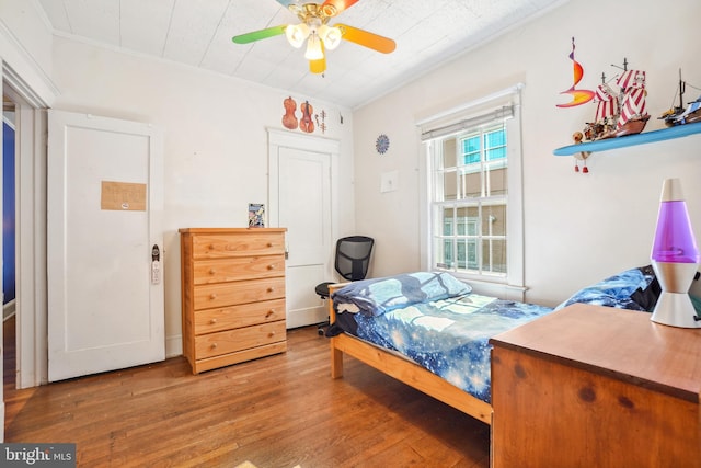 bedroom featuring ornamental molding, ceiling fan, and hardwood / wood-style floors