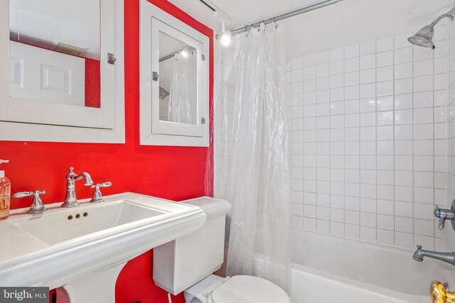 full bath with a sink, toilet, and shower / tub combo