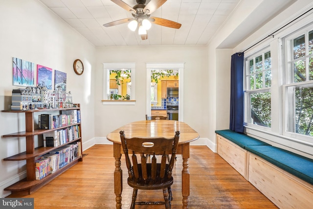 dining area with ceiling fan, ornamental molding, baseboards, and light wood-style floors