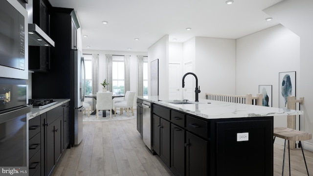 kitchen with built in microwave, a breakfast bar area, dark cabinetry, and a sink