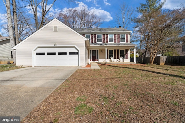 traditional-style house with a front lawn, driveway, a porch, fence, and a garage