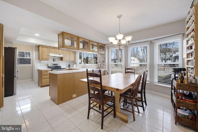 dining room featuring a raised ceiling, a notable chandelier, recessed lighting, light tile patterned flooring, and baseboards