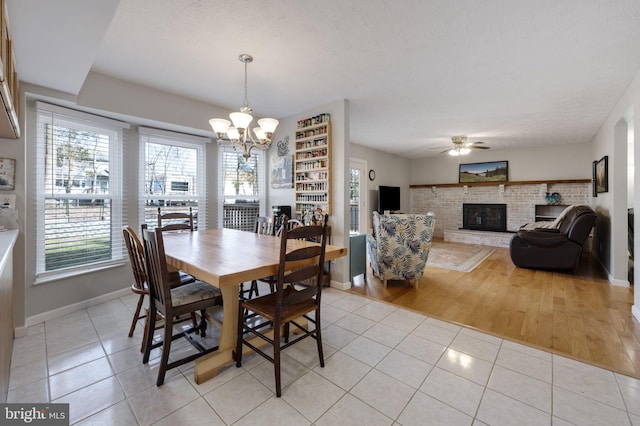 dining space with light tile patterned floors, plenty of natural light, and a brick fireplace