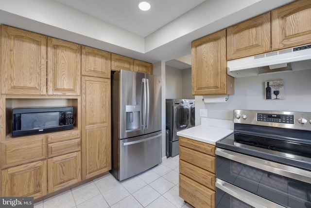 kitchen with under cabinet range hood, light countertops, light tile patterned floors, appliances with stainless steel finishes, and separate washer and dryer