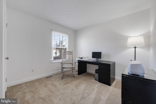 office area with baseboards, light carpet, and a textured ceiling