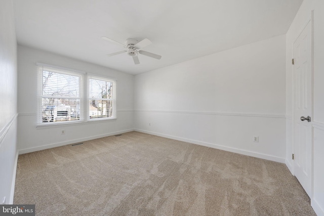 unfurnished room featuring visible vents, carpet floors, baseboards, and ceiling fan