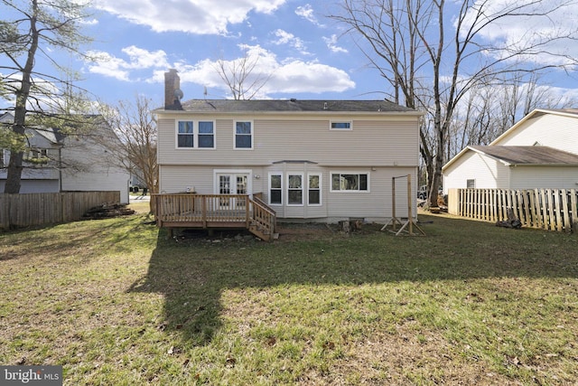 rear view of property featuring fence, a wooden deck, a chimney, french doors, and a lawn