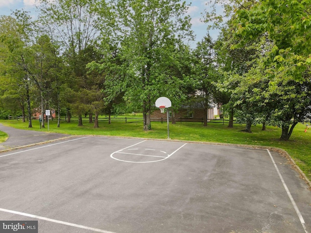 view of sport court with community basketball court, a lawn, and fence