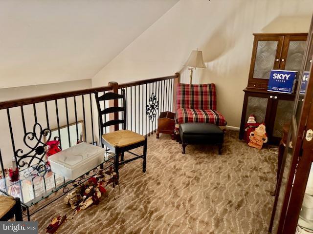 sitting room featuring carpet and vaulted ceiling