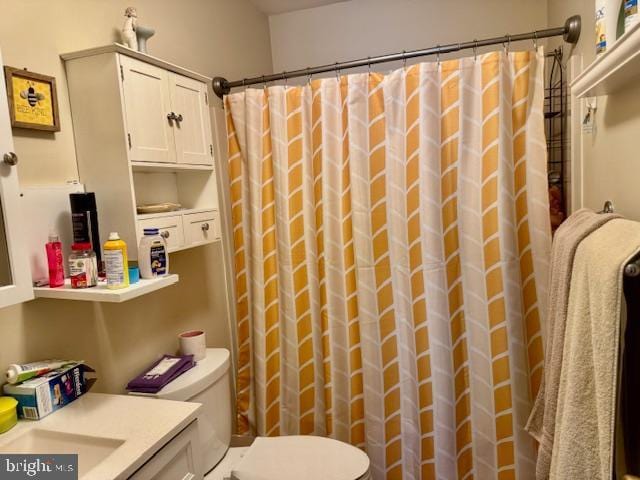 full bath featuring a shower with shower curtain, toilet, and vanity