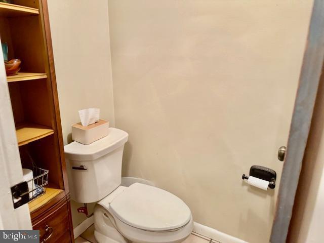 bathroom with toilet and baseboards