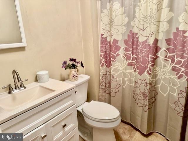 bathroom with toilet, vanity, and a shower with curtain