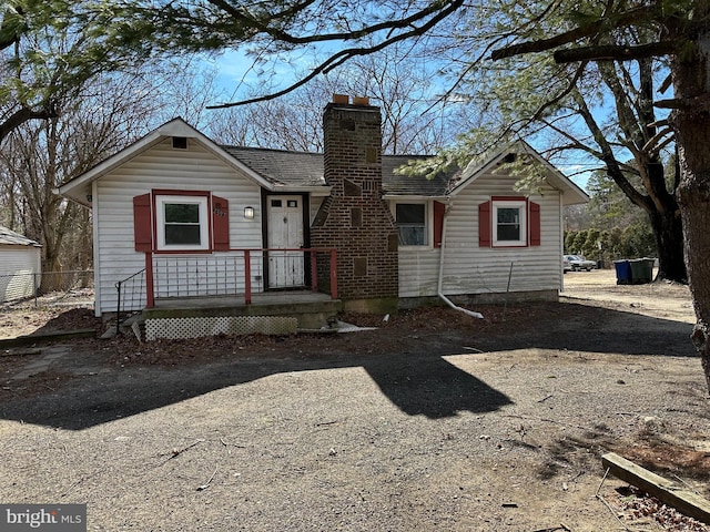 view of front facade featuring driveway and a chimney