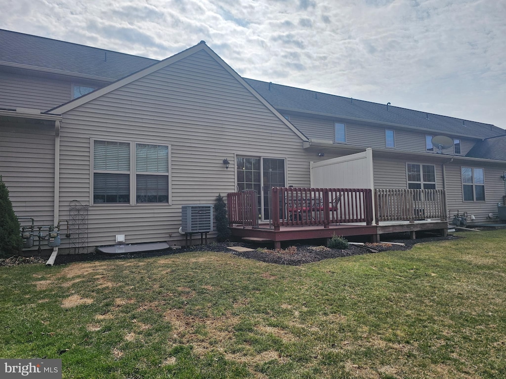 rear view of house with a yard, central AC, and a wooden deck