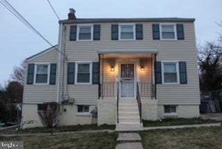 view of front of home featuring a chimney and a front lawn
