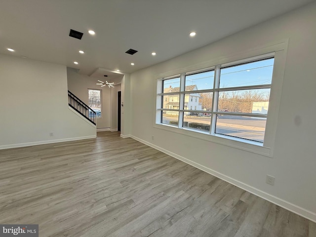 unfurnished living room featuring visible vents, baseboards, stairs, recessed lighting, and light wood-style flooring