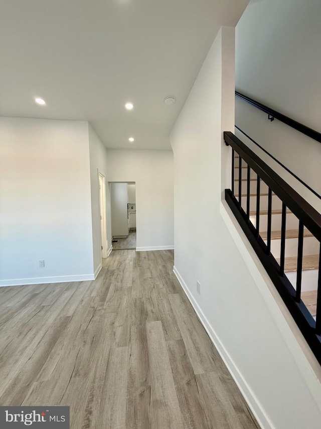 hall featuring stairway, recessed lighting, wood finished floors, and baseboards