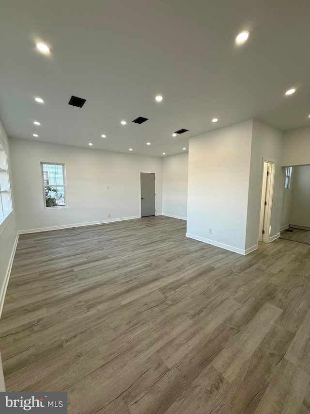 empty room featuring recessed lighting, baseboards, and wood finished floors