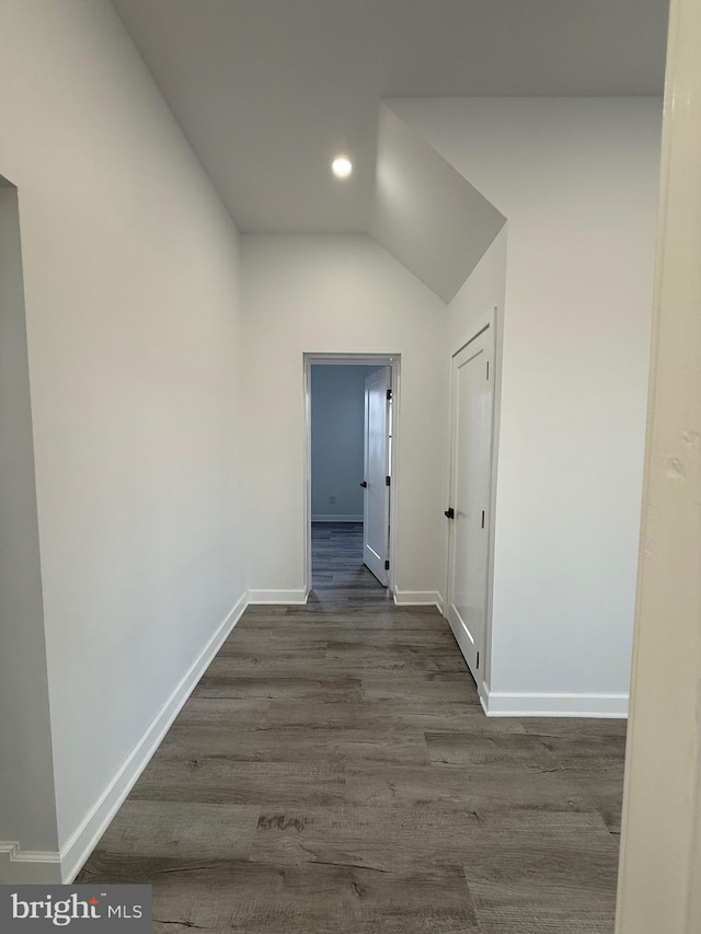 corridor featuring dark wood-style floors, recessed lighting, lofted ceiling, and baseboards