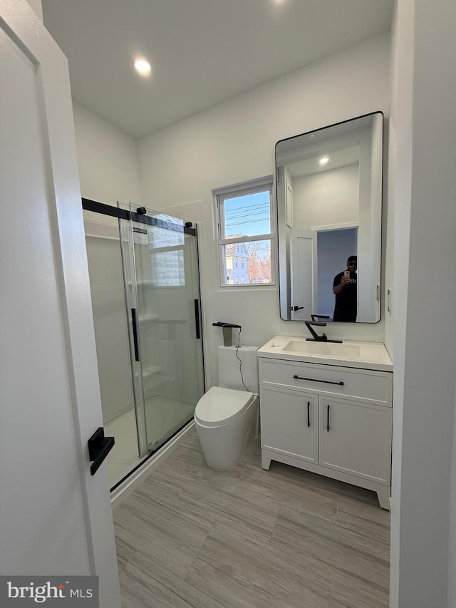 full bathroom featuring recessed lighting, a stall shower, toilet, and vanity