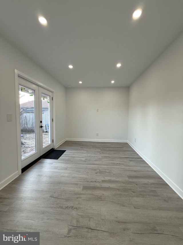 unfurnished room featuring recessed lighting, french doors, baseboards, and wood finished floors