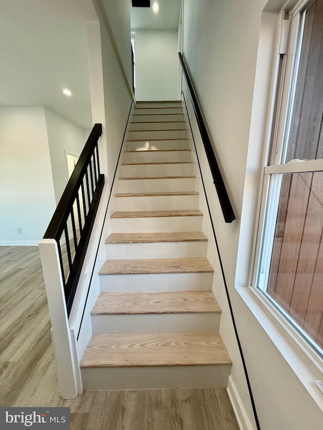 stairs featuring wood finished floors and baseboards