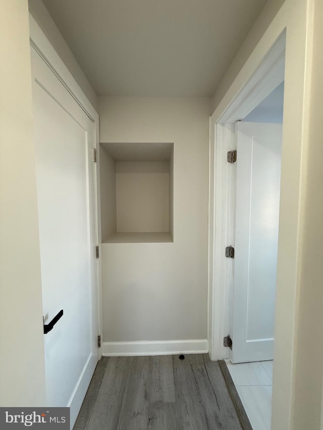 hall featuring baseboards and wood finished floors