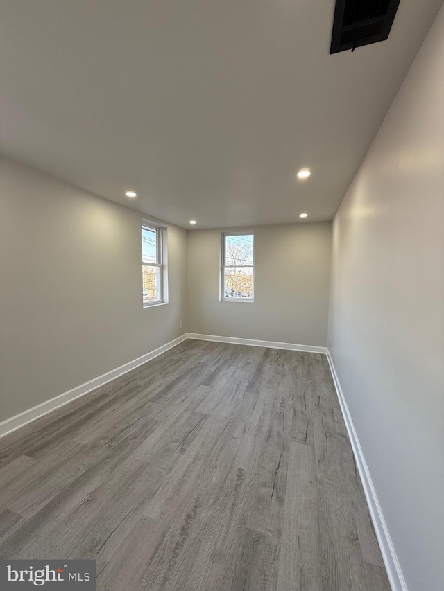 spare room featuring visible vents, recessed lighting, wood finished floors, and baseboards