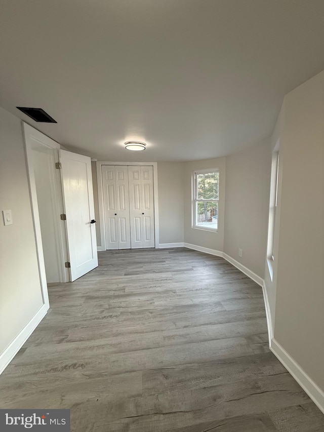 unfurnished bedroom featuring wood finished floors and baseboards