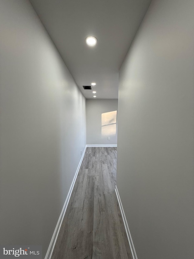 hall featuring recessed lighting, visible vents, baseboards, and wood finished floors