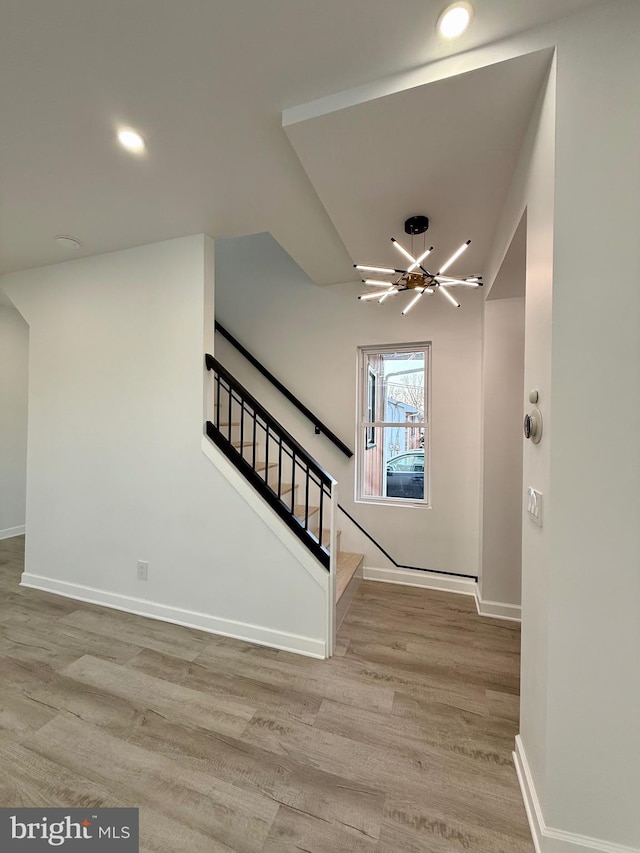 entryway featuring wood finished floors, recessed lighting, baseboards, a chandelier, and stairs