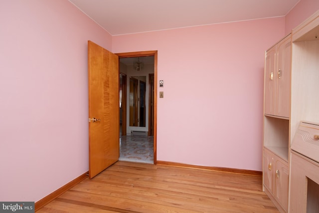 empty room with baseboards and light wood-style floors