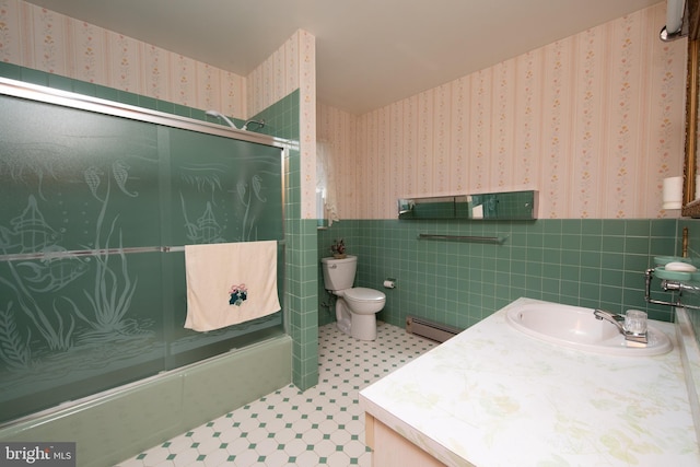 full bathroom with a wainscoted wall, a baseboard radiator, wallpapered walls, bath / shower combo with glass door, and toilet