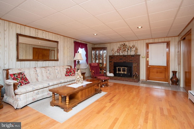 living room with a brick fireplace and wood finished floors