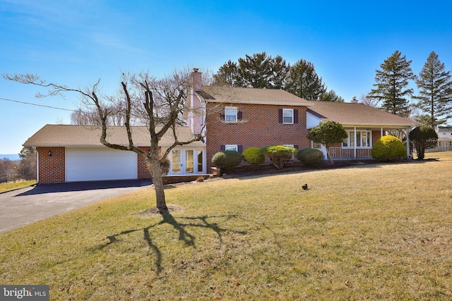 view of front of home with aphalt driveway, a front lawn, brick siding, and a chimney