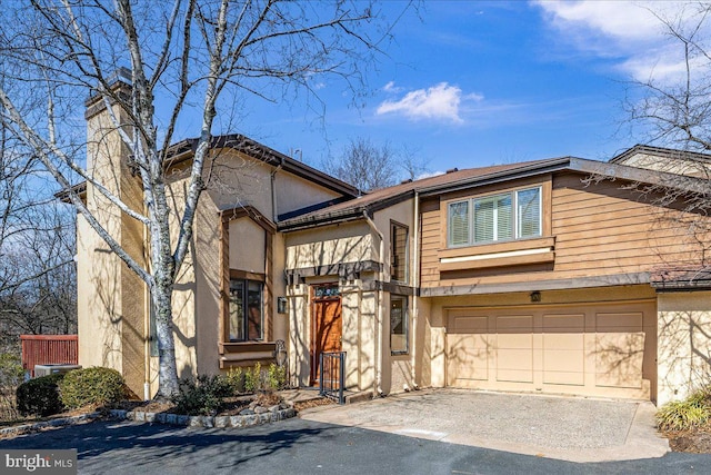 view of front of home with aphalt driveway, stucco siding, and a garage