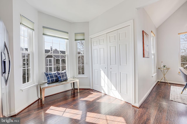 entryway with hardwood / wood-style flooring, baseboards, and vaulted ceiling