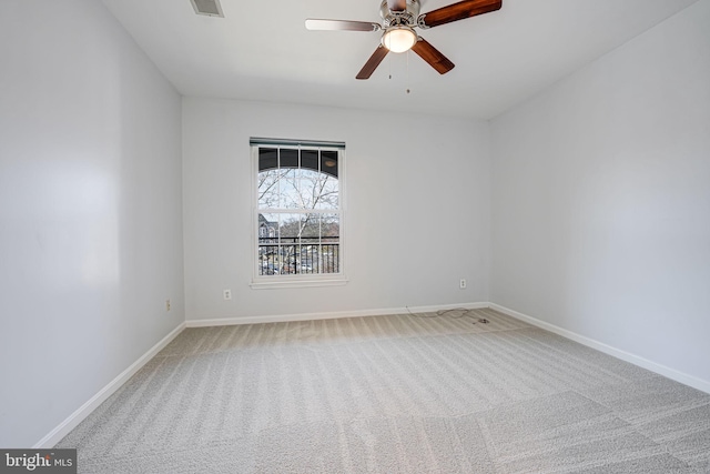 carpeted empty room featuring a ceiling fan and baseboards