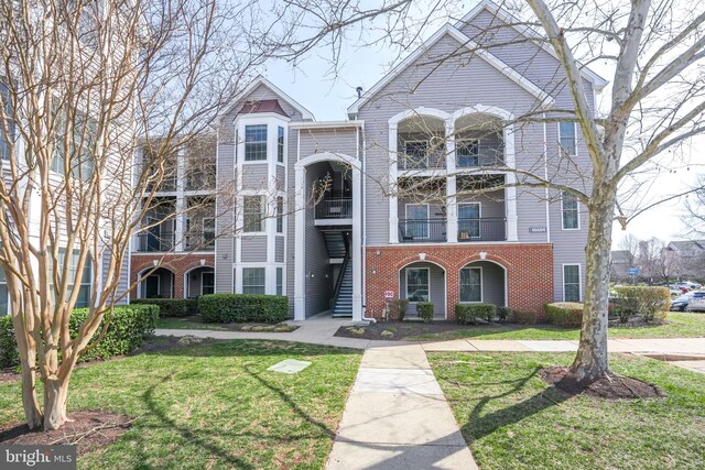 view of front of house with brick siding and a front lawn