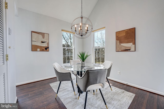 dining area with a chandelier, dark wood finished floors, high vaulted ceiling, and baseboards