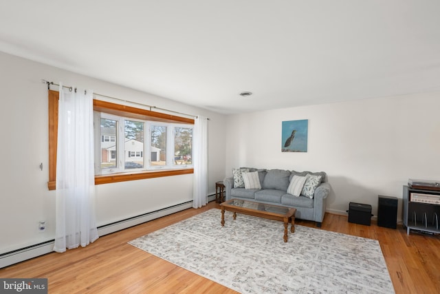 living room with visible vents, a baseboard radiator, and wood finished floors